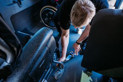 TSMO staff securing a wheelchair inside the vehicle